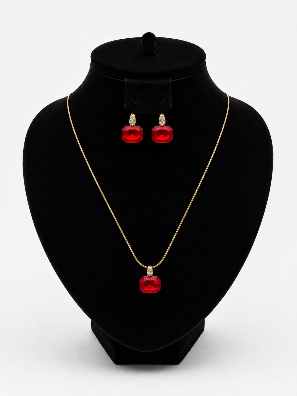 Parure de bijoux dorés à pierres rouges